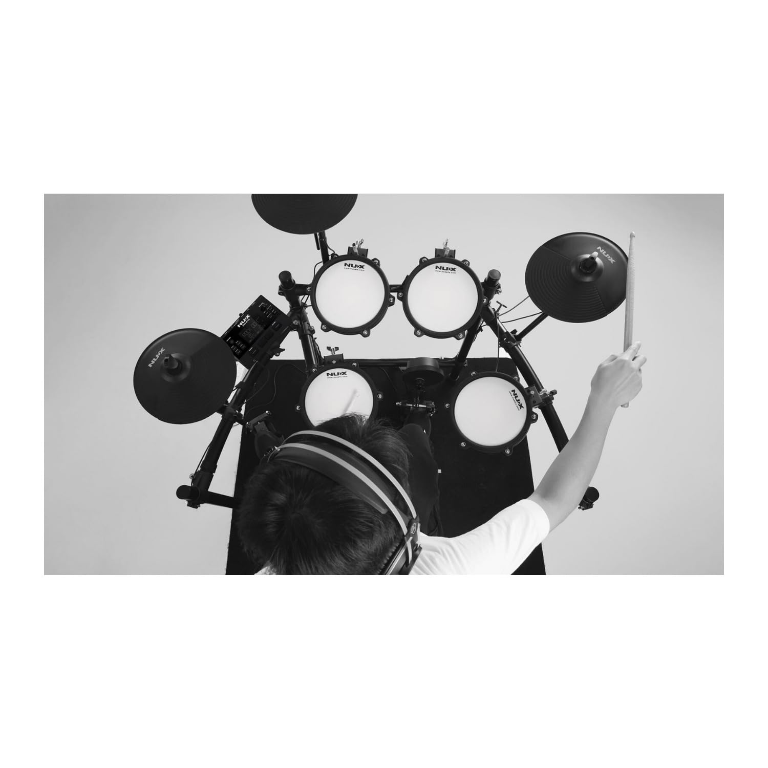 Drummer practising on the NUX DM-210 with headphones